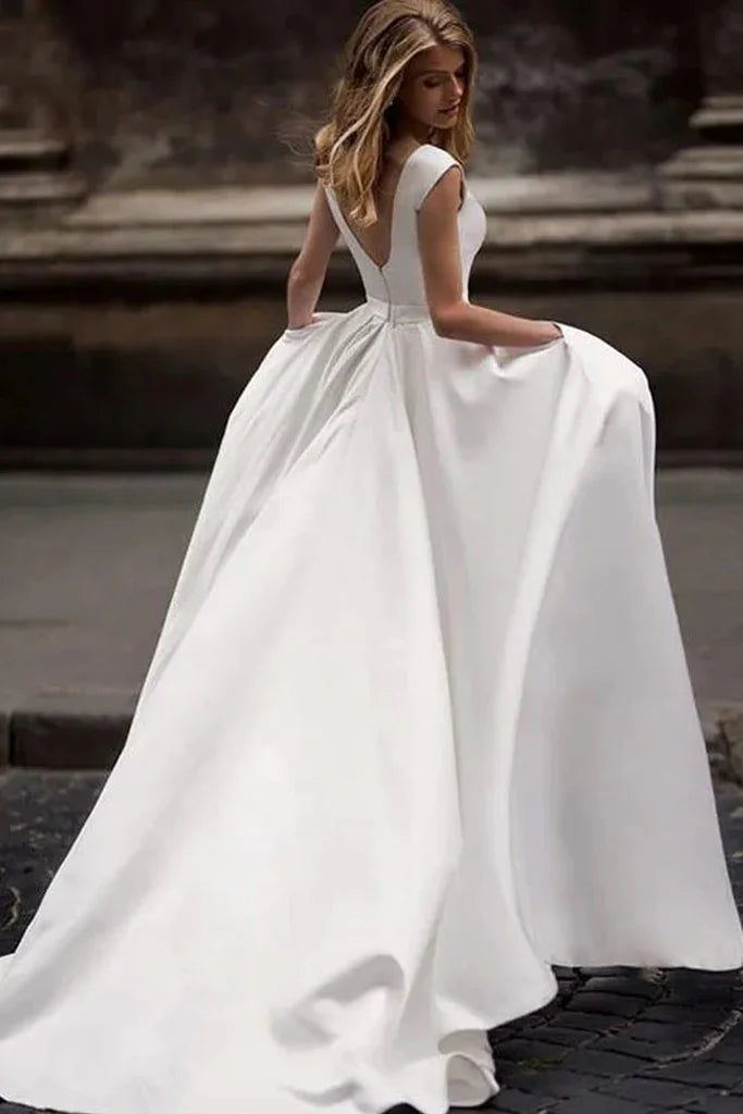 Minimalist satin ball gown wedding dress with cap sleeves, deep V-back and side pockets